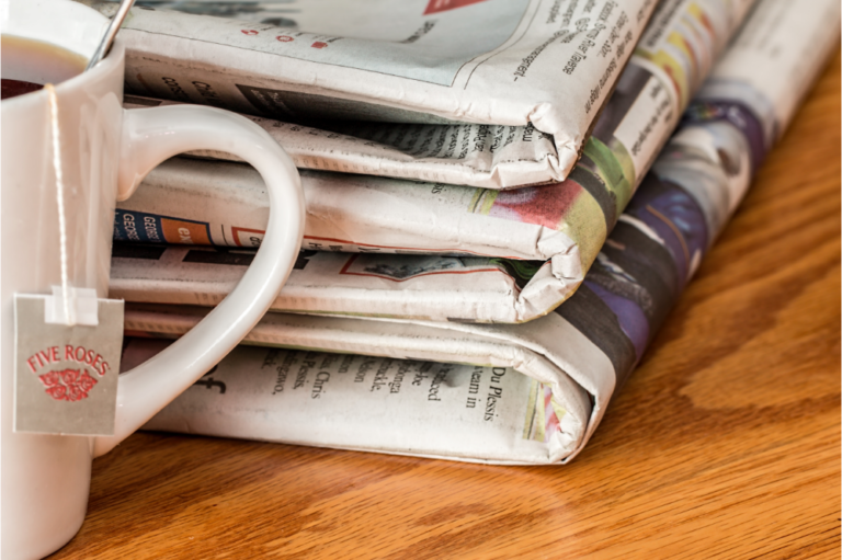 a stack of newspapers showing print media relevancy