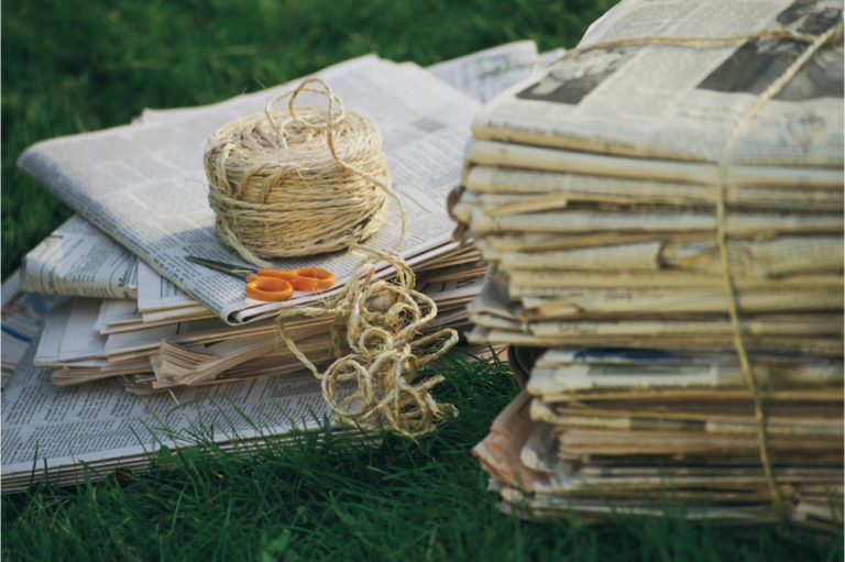 a bundle of newspapers ready to be recycled, representing print media companies