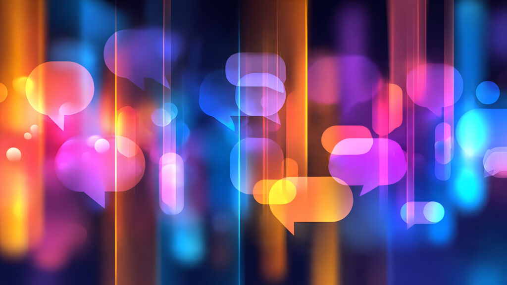 Abstract blurred image of glowing speech bubble icons in blue, orange and pink