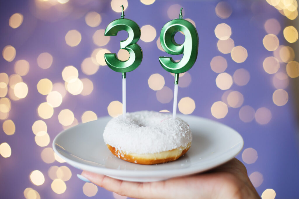 A 3 and a 9 candle on a white doughnut