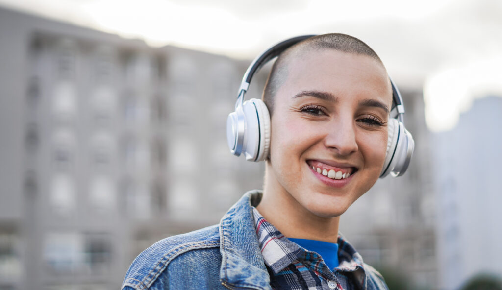 A young person smiles with headphones on